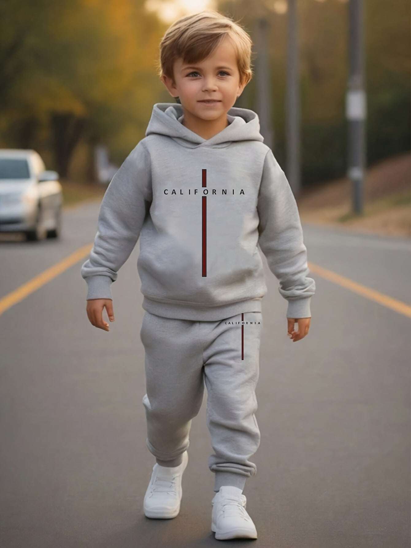Trendy boys' California print outfit set with hooded sweatshirt and joggers on a stylish child outdoors.