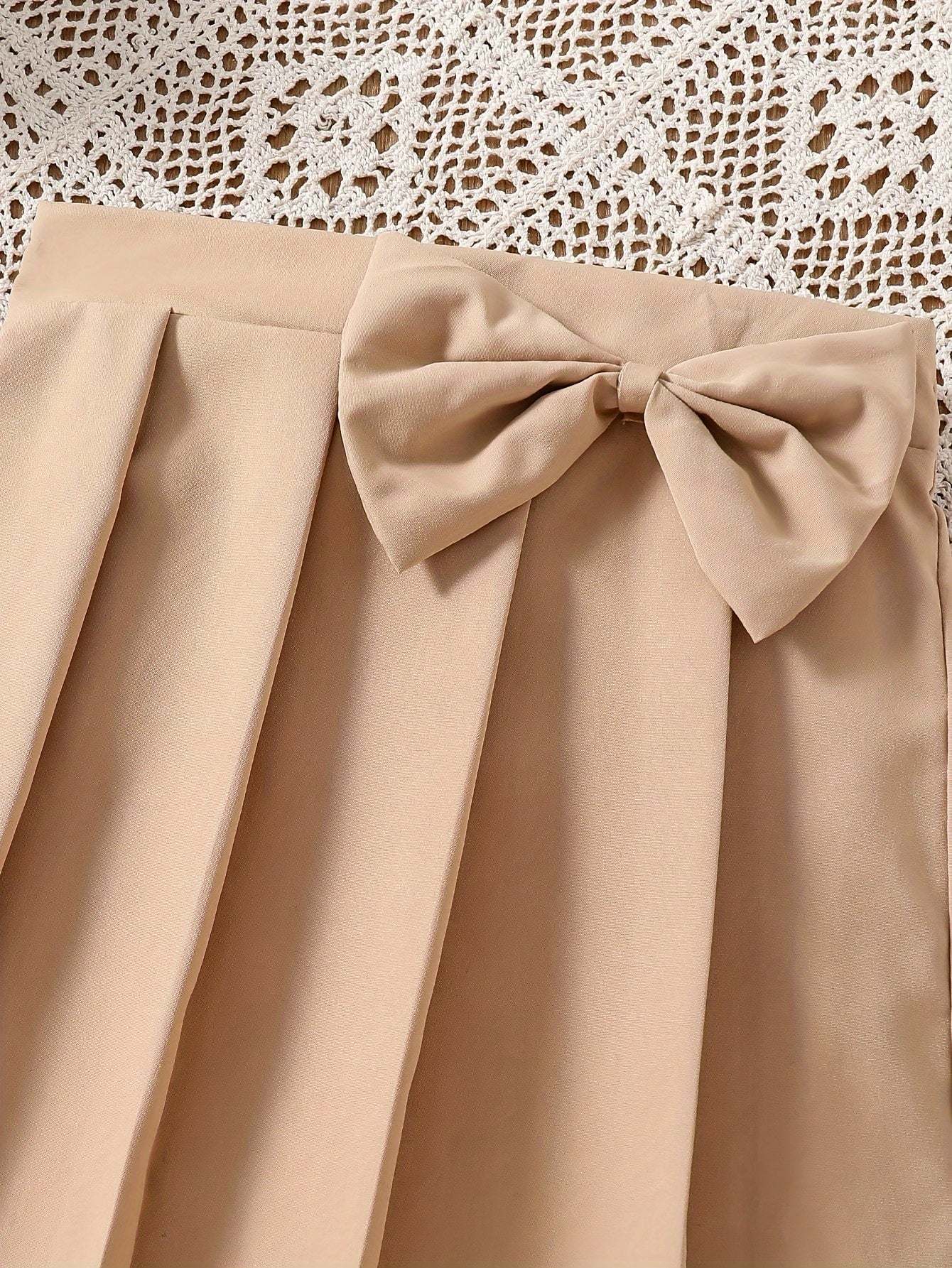 Chic pleated beige skirt with bow detail for girls.