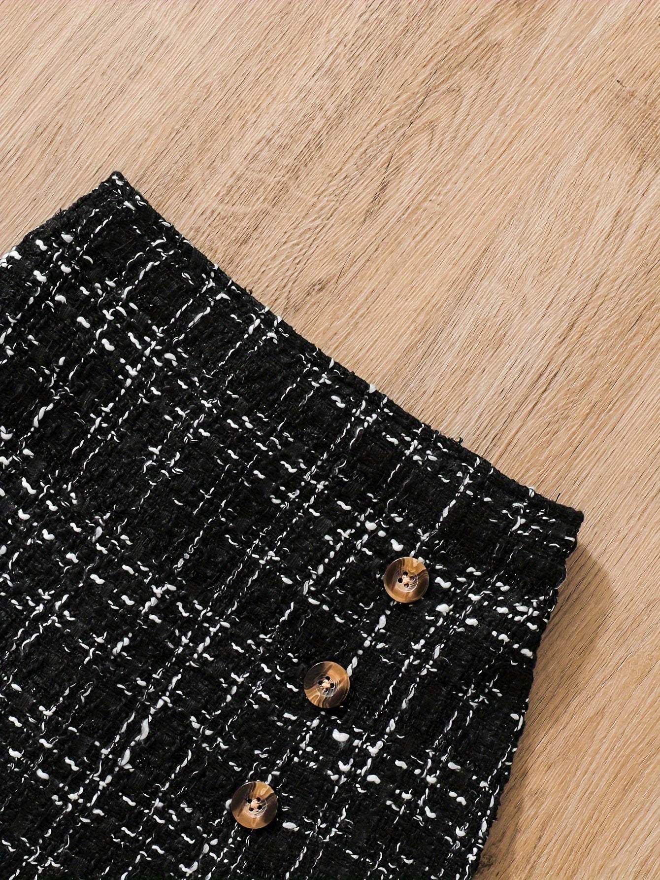 Close-up of a tweed knit skirt with button details from a 2-piece set.