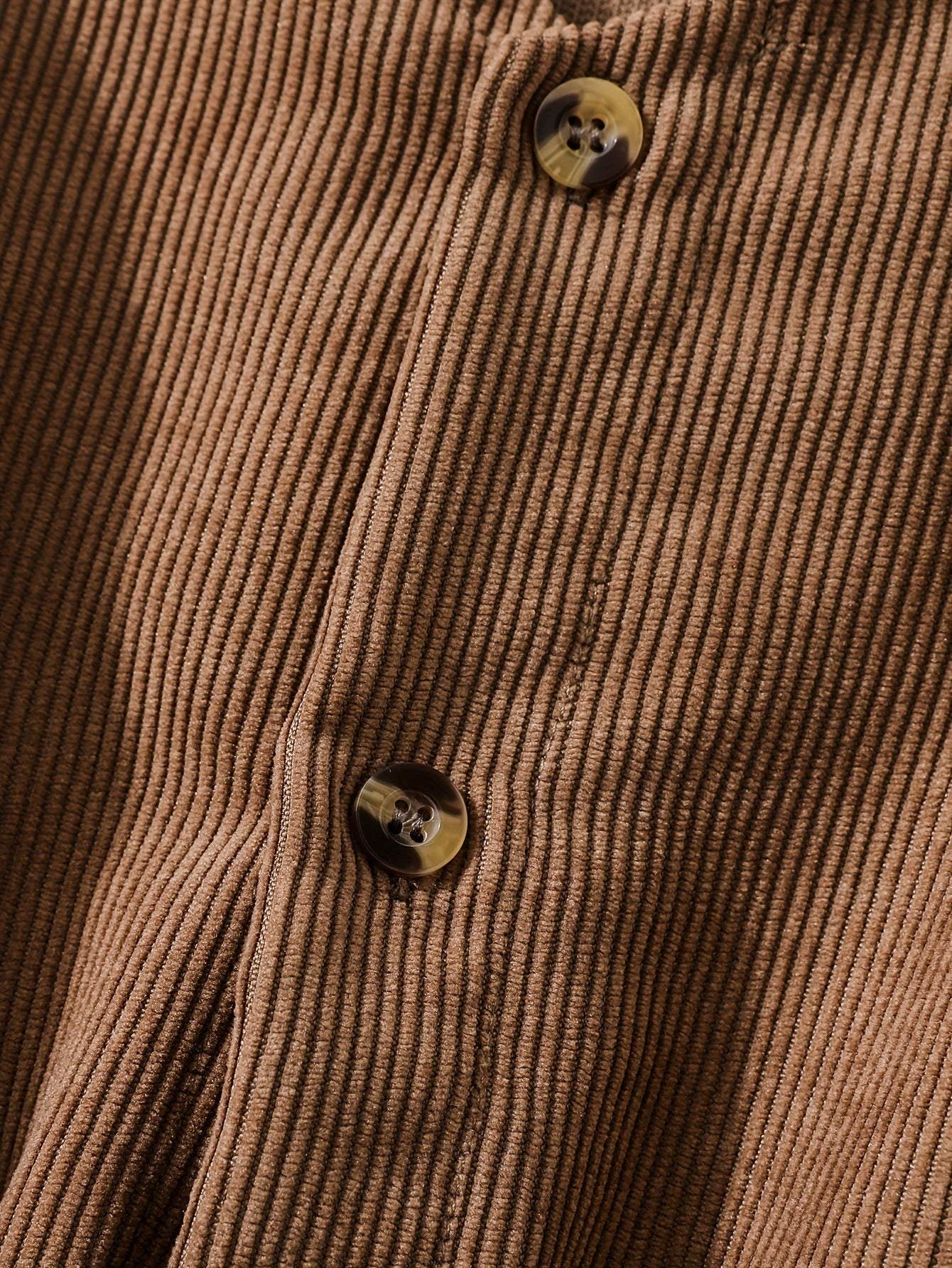 Close-up of button details on a fashionable ribbed polyester fabric from a two-piece dress collection.