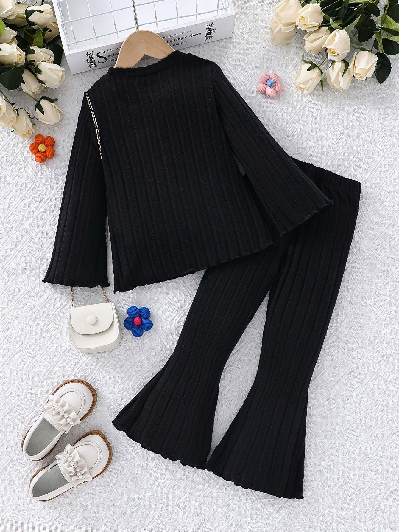 Stylish girls' black outfit set with ribbed knit fabric, perfect for casual and formal occasions.