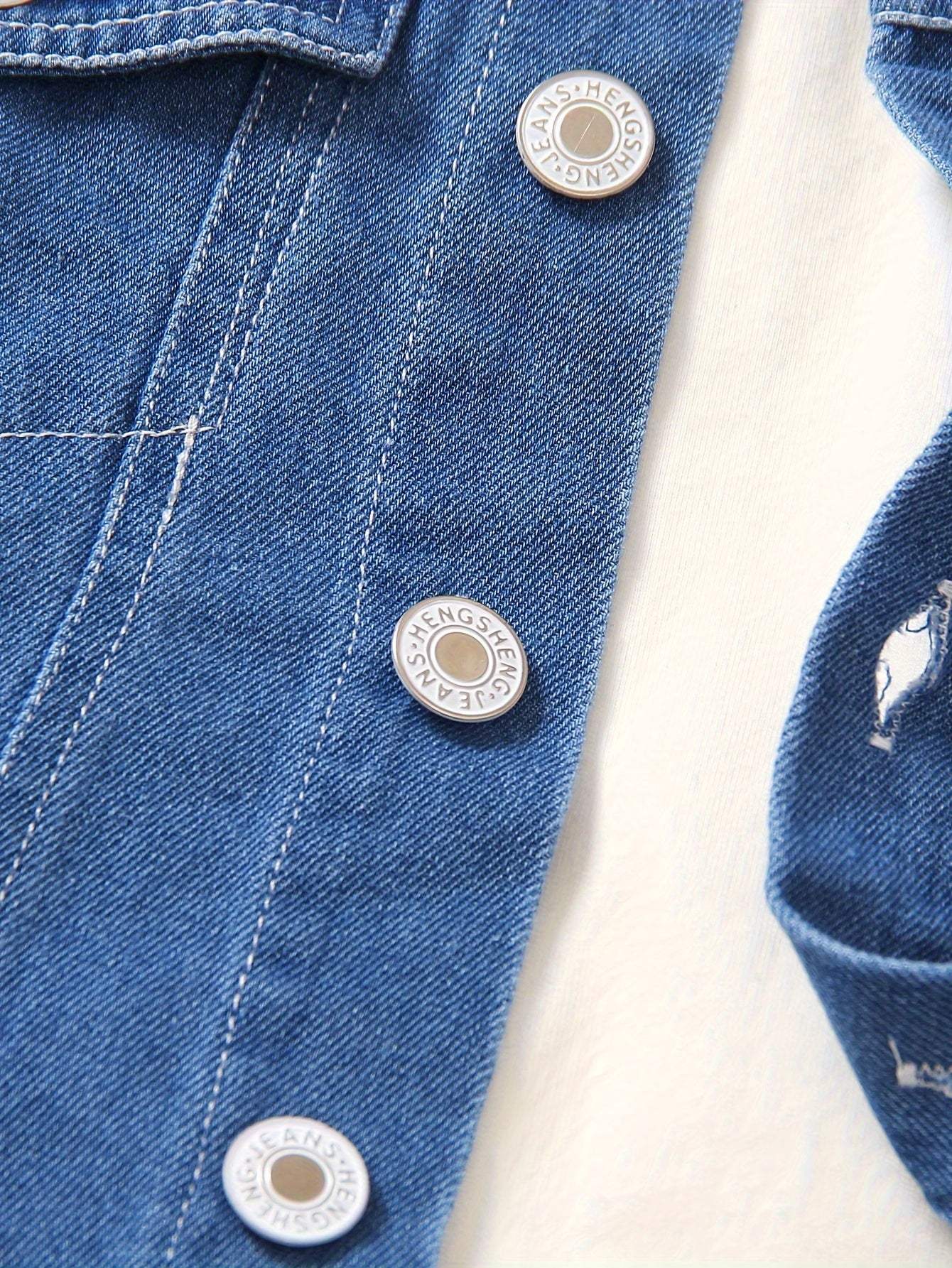 Close-up of denim fabric and buttons from the cool boys' casual denim outfit set.