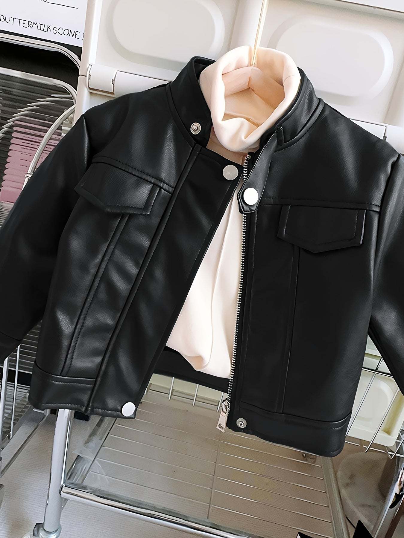 Trendy black leather jacket for girls with zipper and button details, perfect for winter outings.