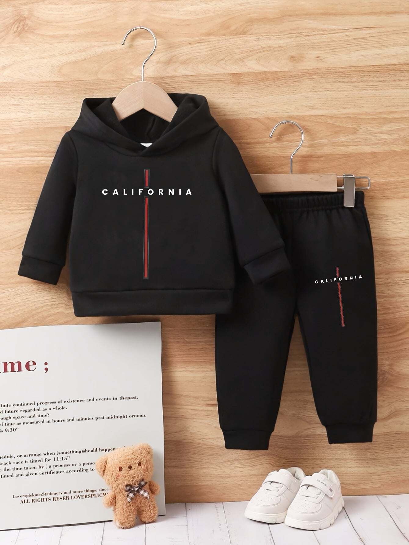 Trendy boys' California print outfit set with hoodie and sweatpants on wooden background.