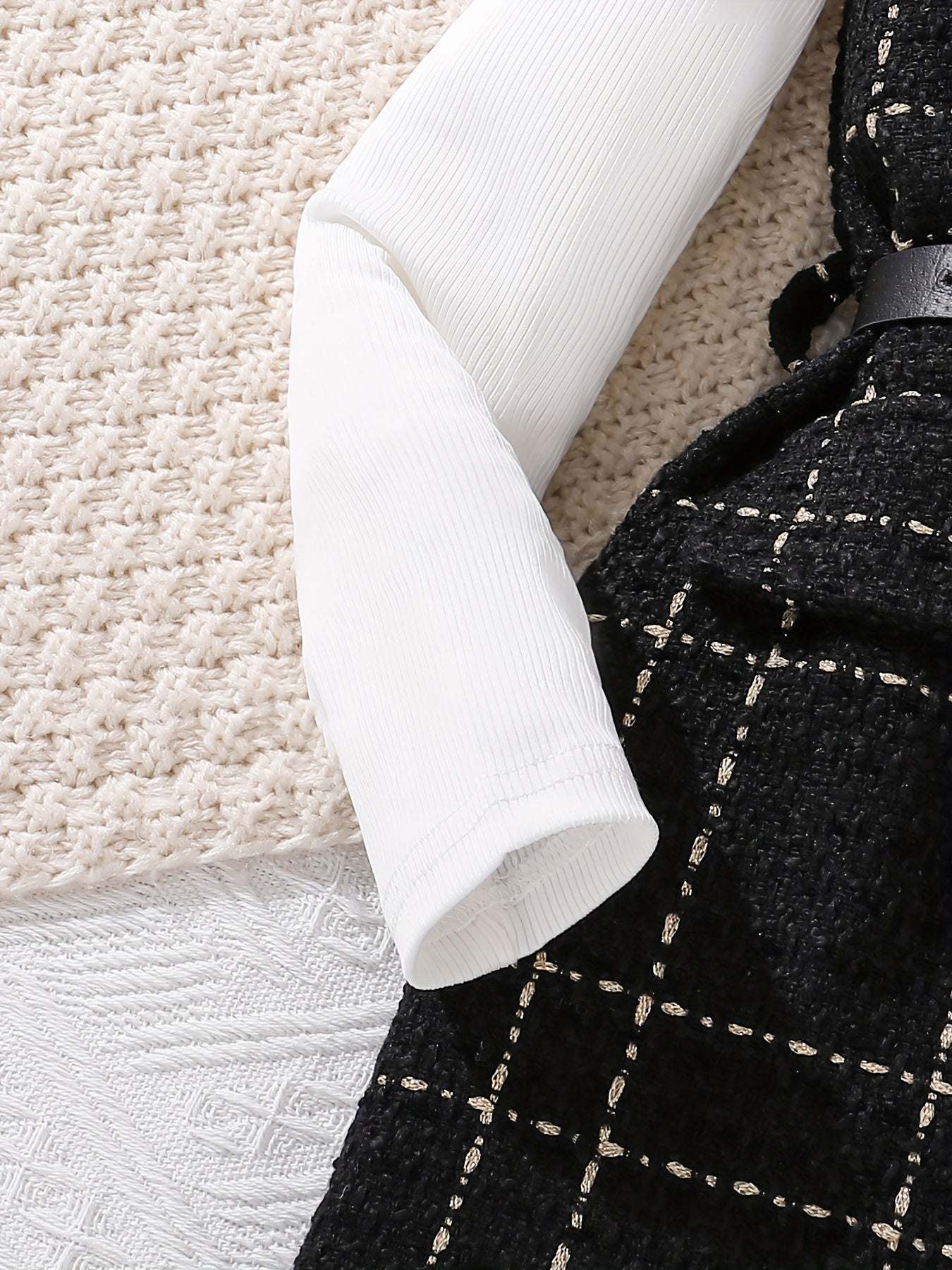 Trendy girls' two-piece fall outfit with cozy plaid design and ribbed white sleeves.