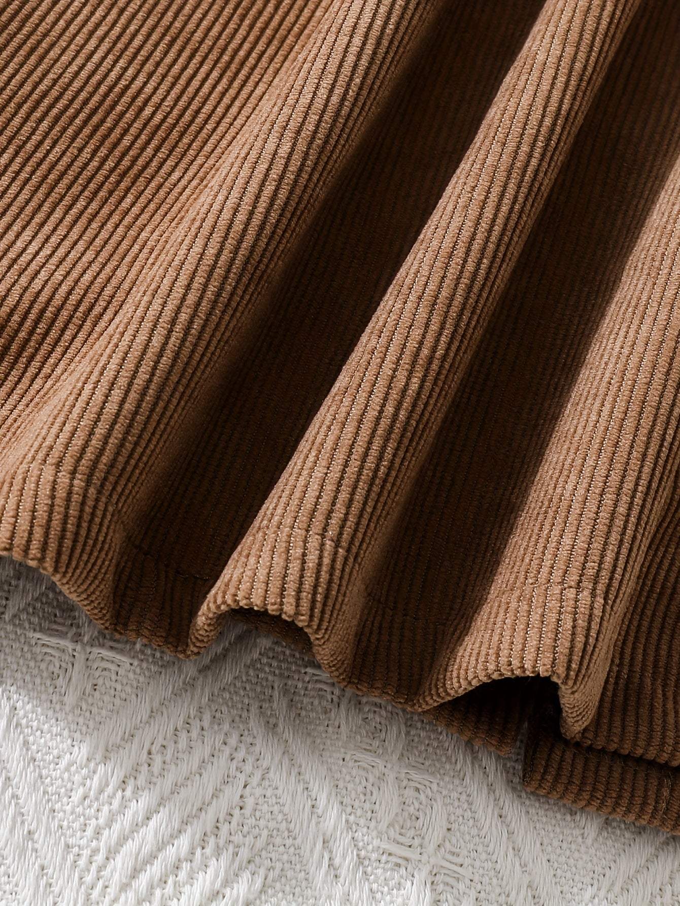 Fashionable two-piece dress in brown ribbed polyester fabric.