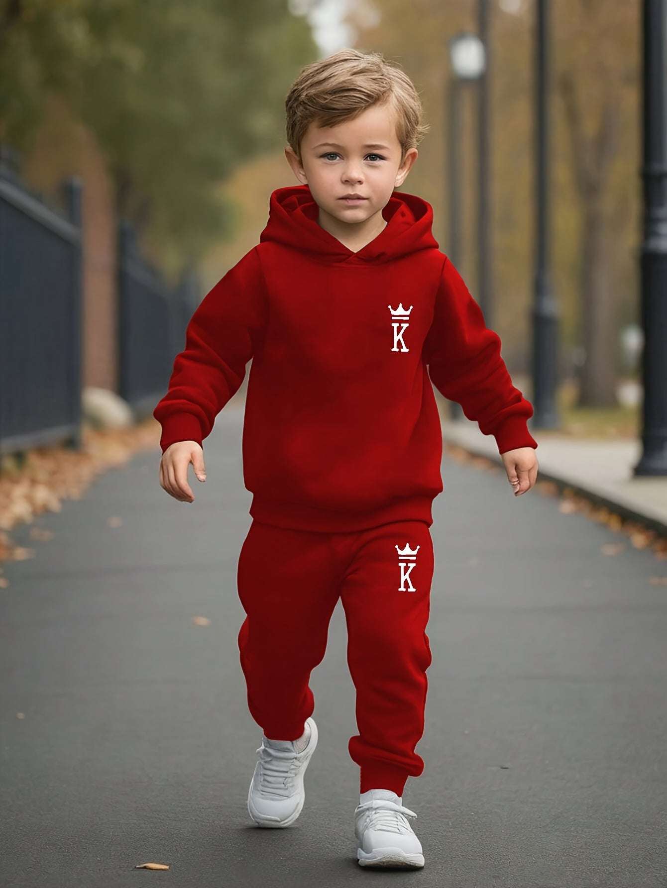 Boy wearing red hoodie and pants set with king logo, perfect for autumn and winter activities.