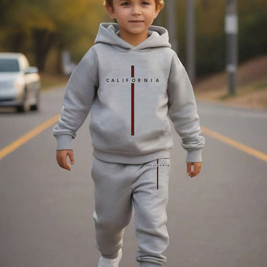 Boy wearing trendy California print outfit with hooded sweatshirt and joggers, perfect for fall and winter seasons.