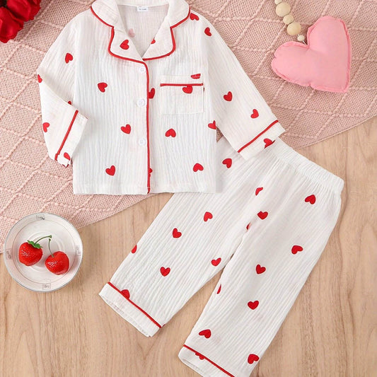 Adorable heart-patterned girls' pajama set with red trim, made from soft, breathable cotton for comfort.