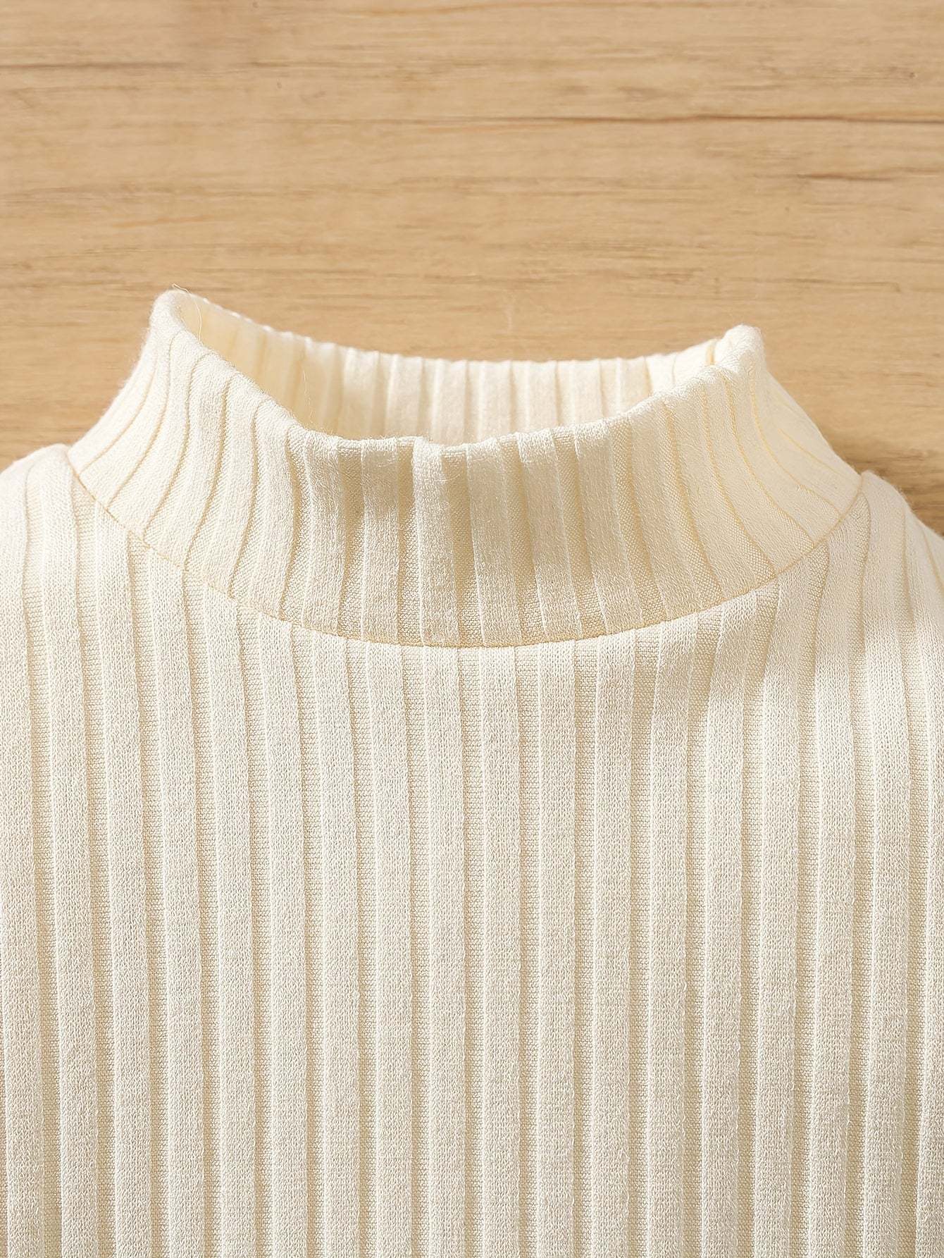 Close-up of a ribbed knit cream-colored fabric from a stylish two-piece set, featuring a chic design ideal for fall and winter.