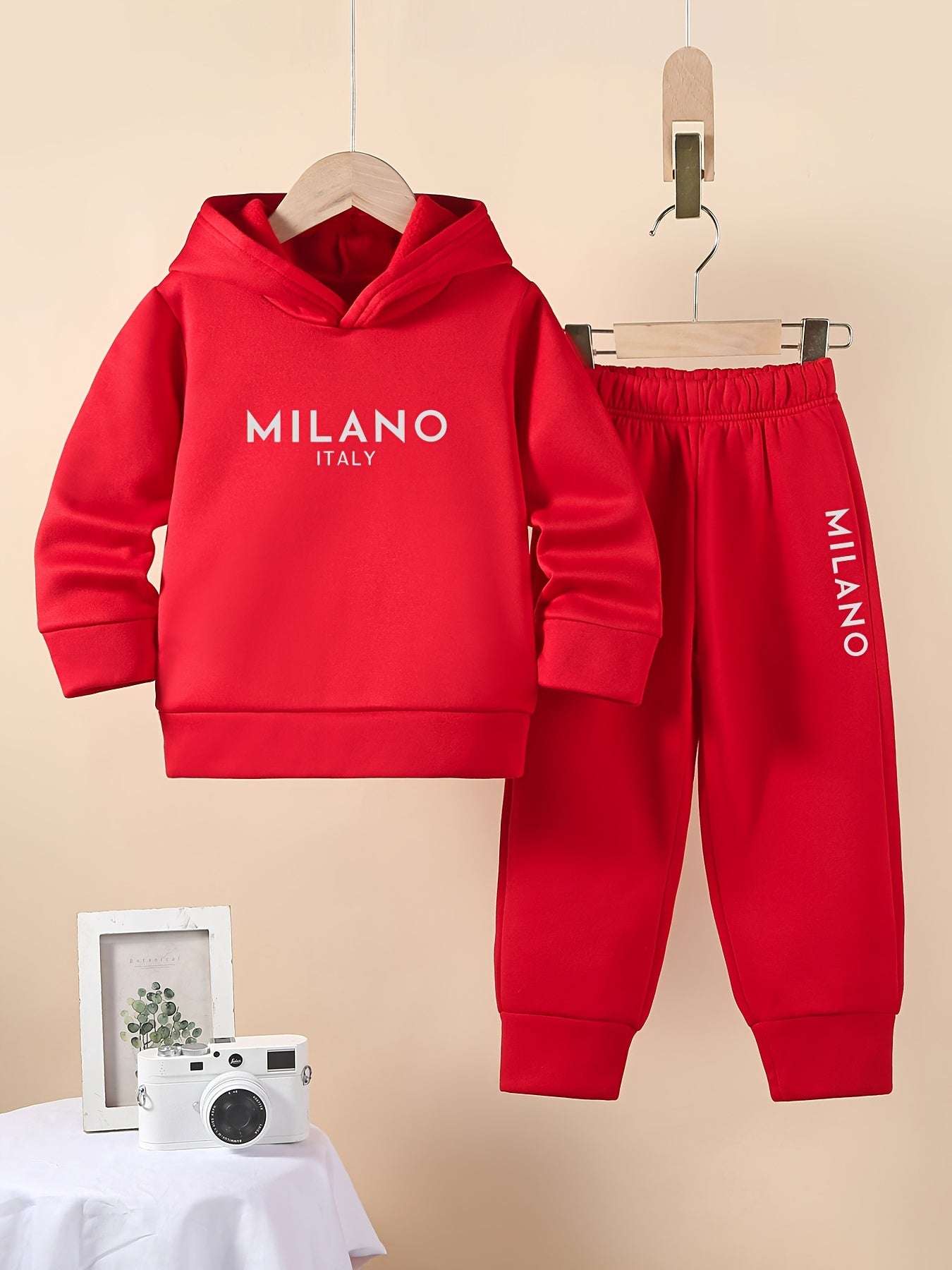 Stylish red boys' Milano set with hoodie and pants displayed on hangers.