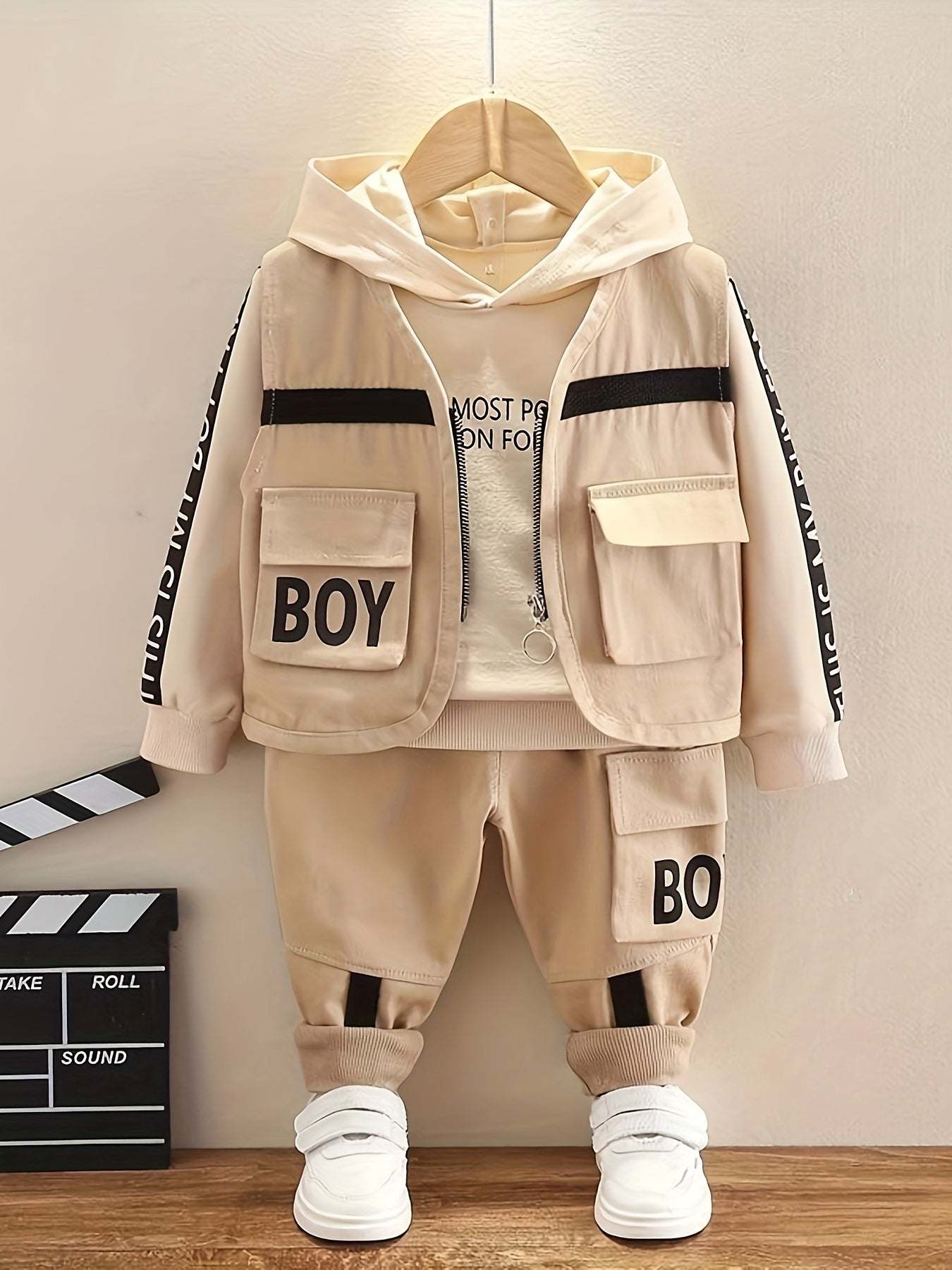 Trendy boys' three-piece set with bold "Boy" design, featuring a jacket, shirt, and pants in beige tones.