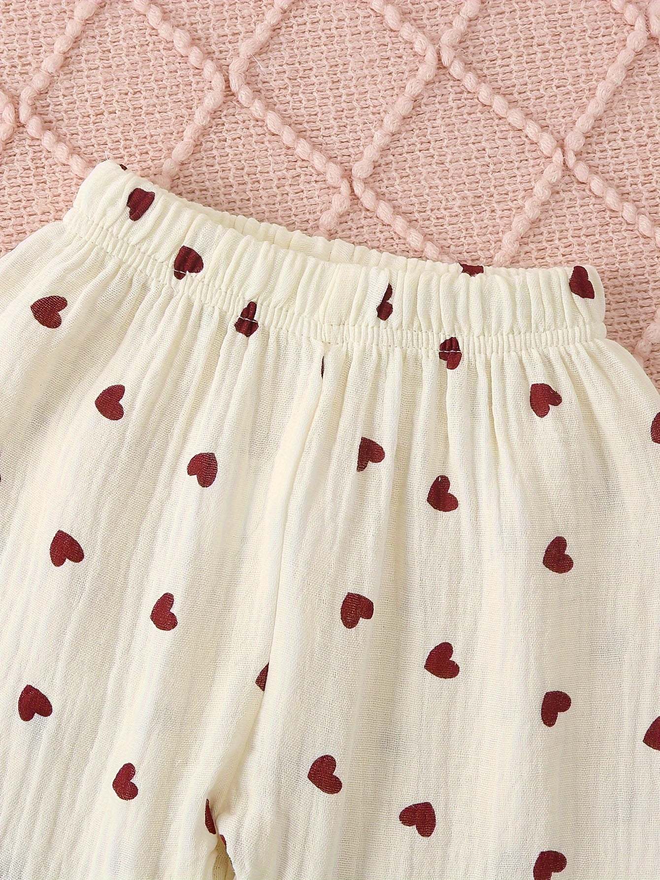 Adorable heart-patterned pajama set for girls made from soft cotton with elastic waistband.
