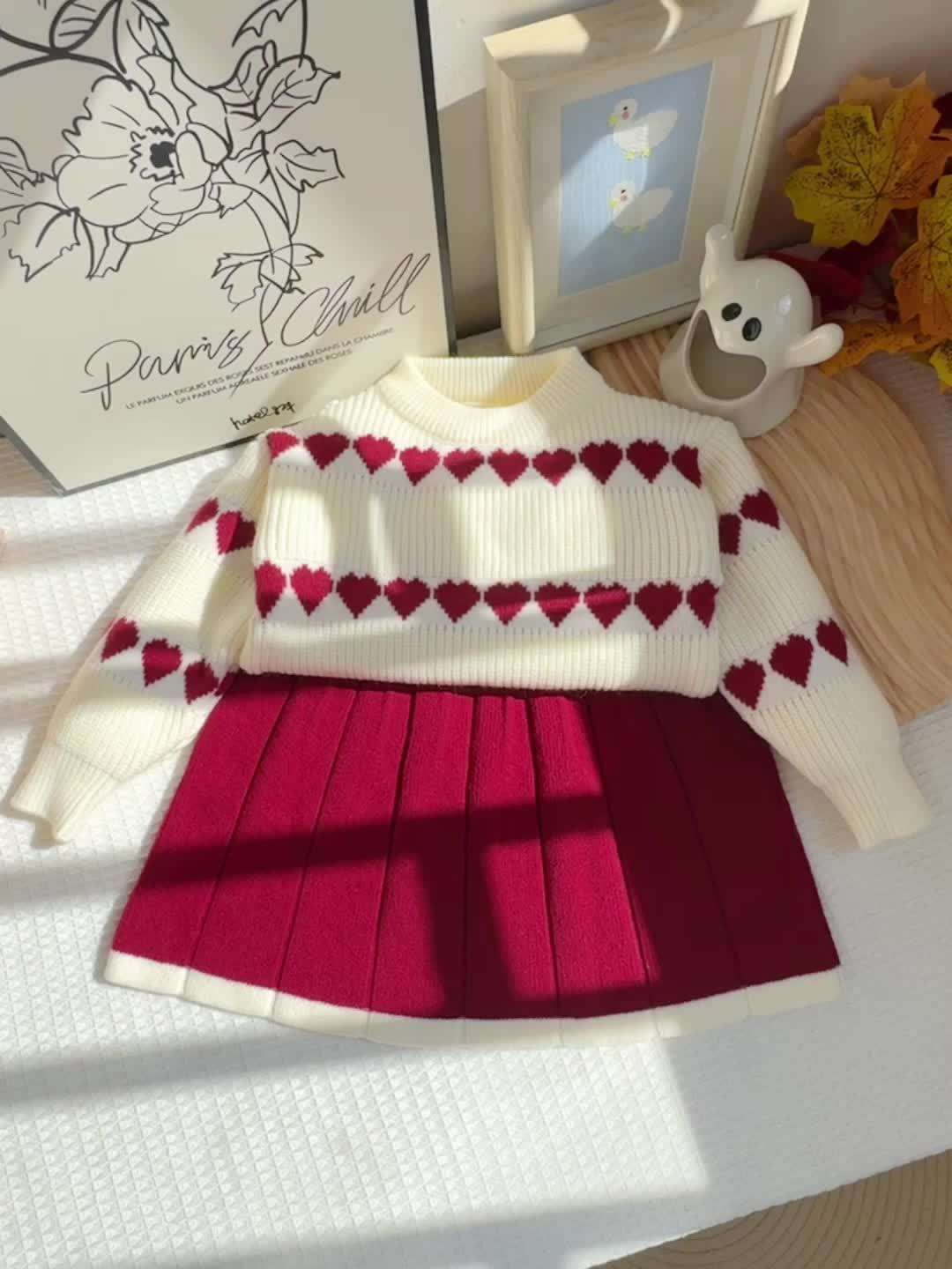 Adorable heart-patterned kids' set with white top and red pleated skirt.