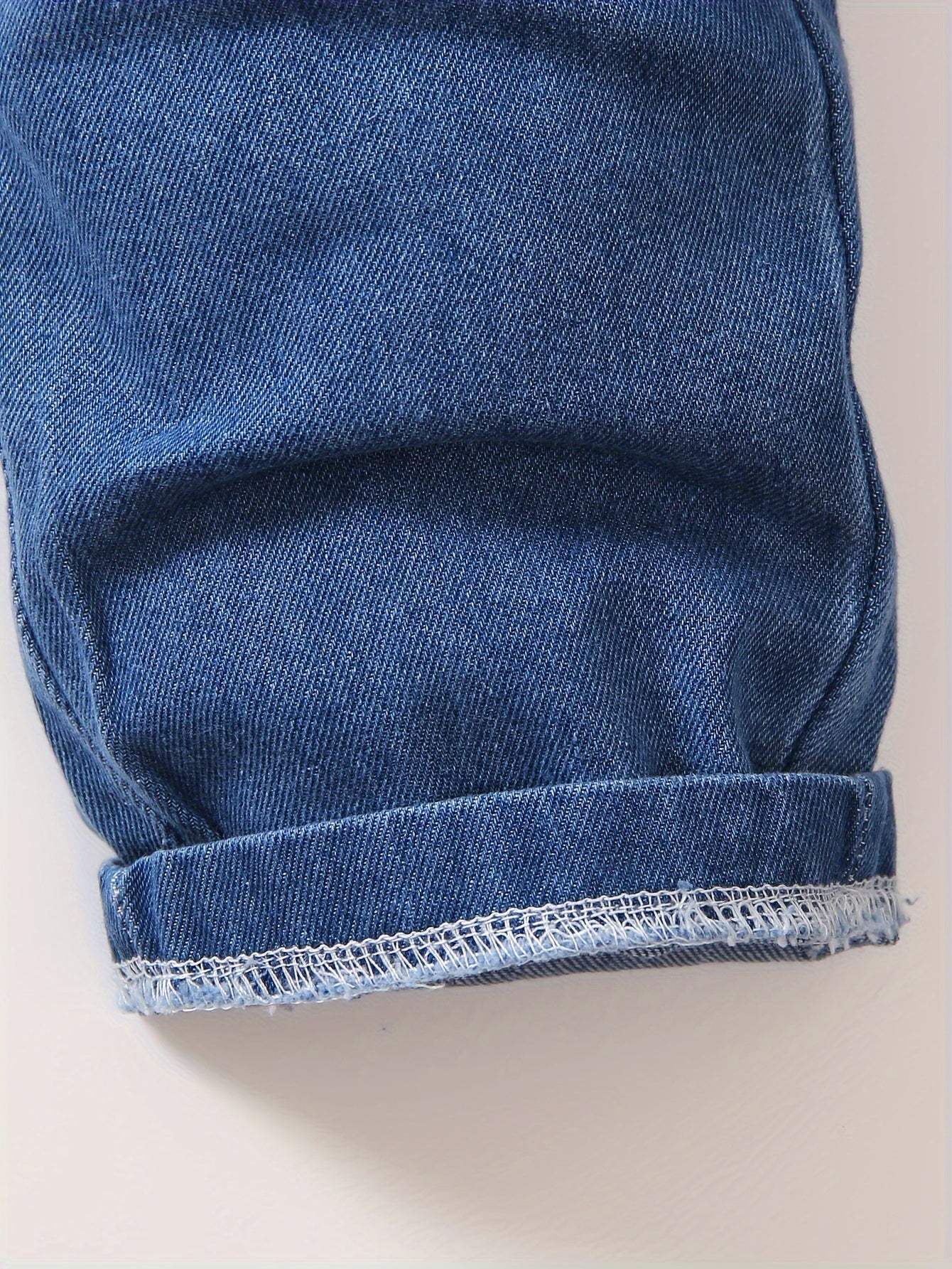 Close-up of cool boys' denim cuffed pant leg.