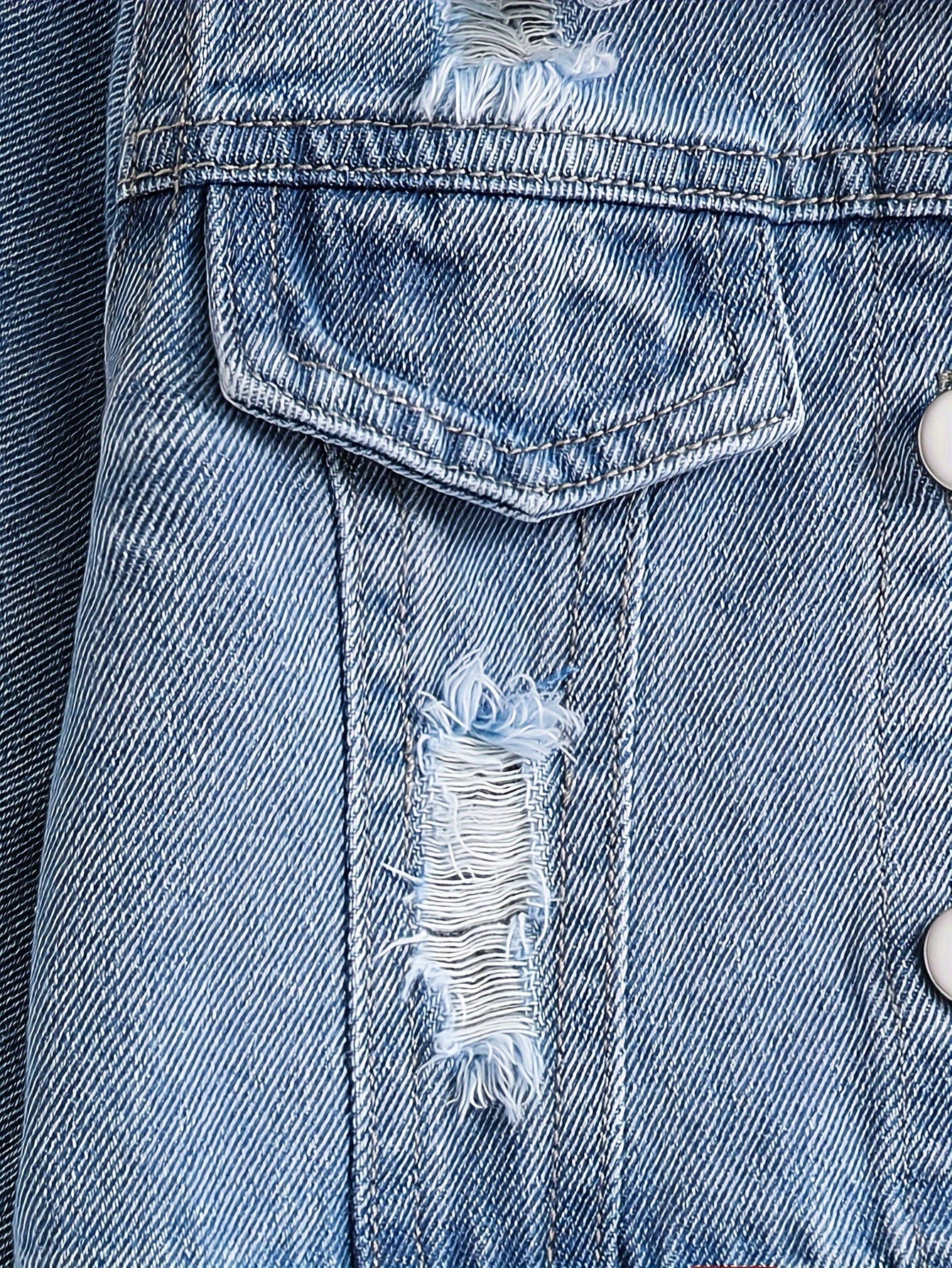 Close-up of fashionable girls' denim jacket with frayed detailing.