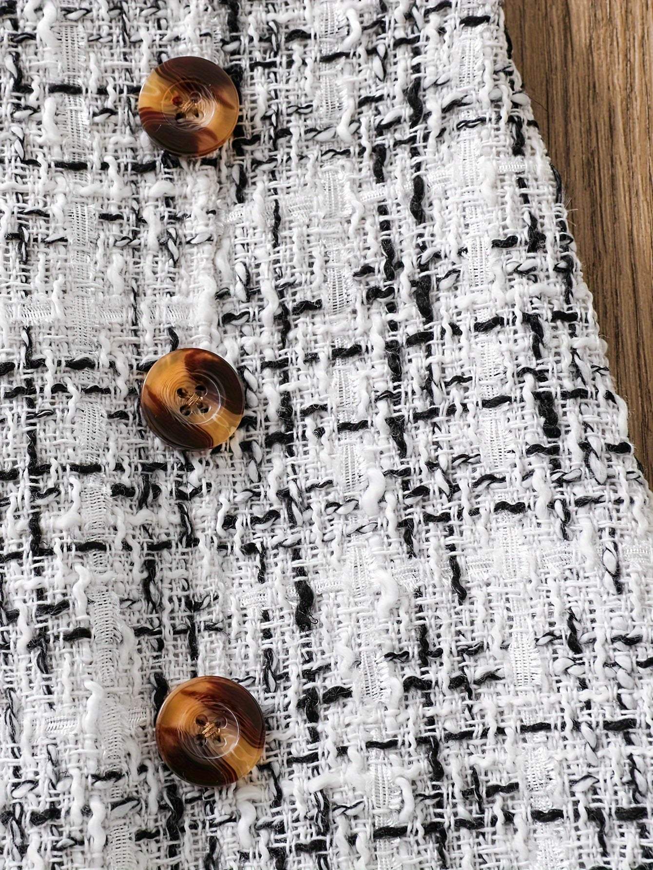Close-up of tweed knit skirt with brown buttons from 2-piece set.