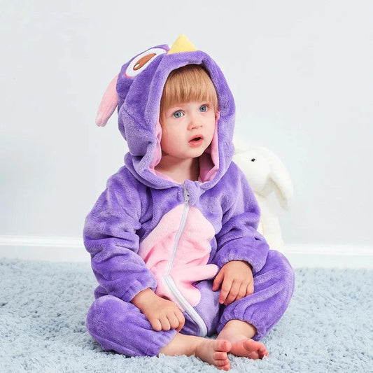 Cute baby in purple animal-themed jumpsuit sitting on soft rug.