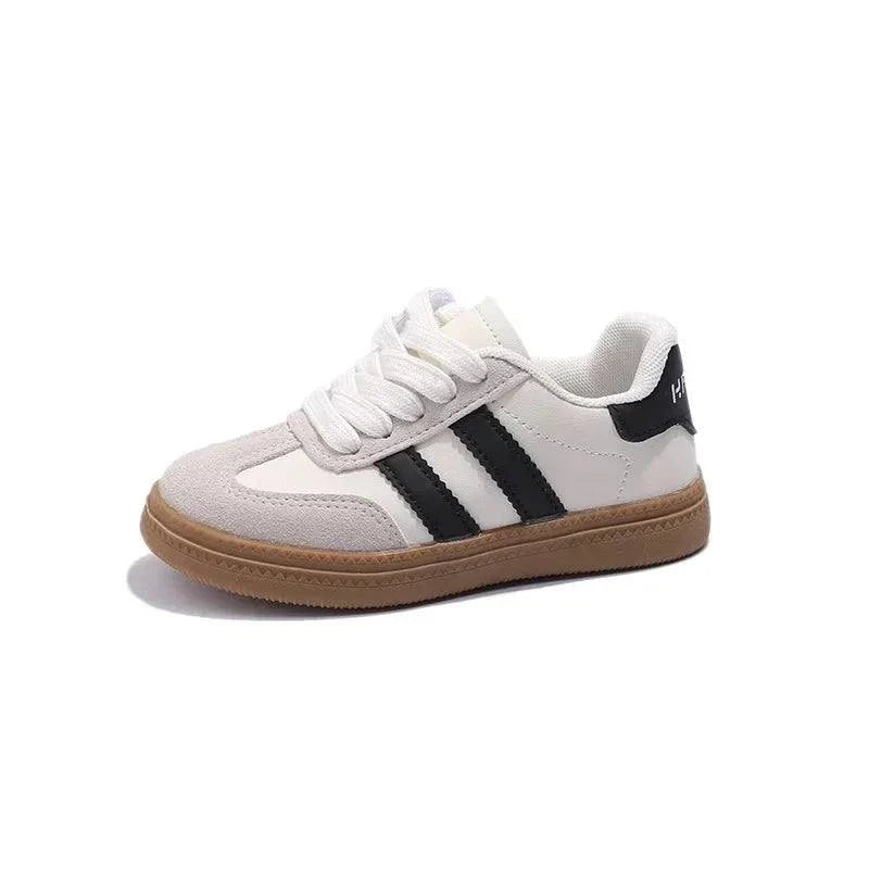 Unisex kids' sneakers with white and black design, featuring durable PU leather and rubber outsole for all-day comfort.