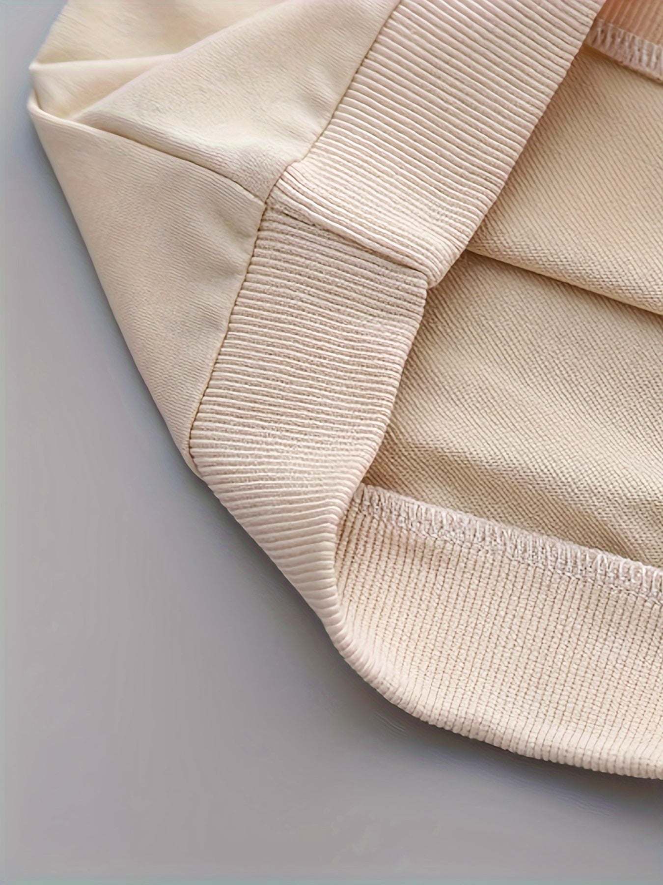 Close-up of trendy boys' three-piece set fabric showcasing high-quality, breathable cotton with slight stretch.