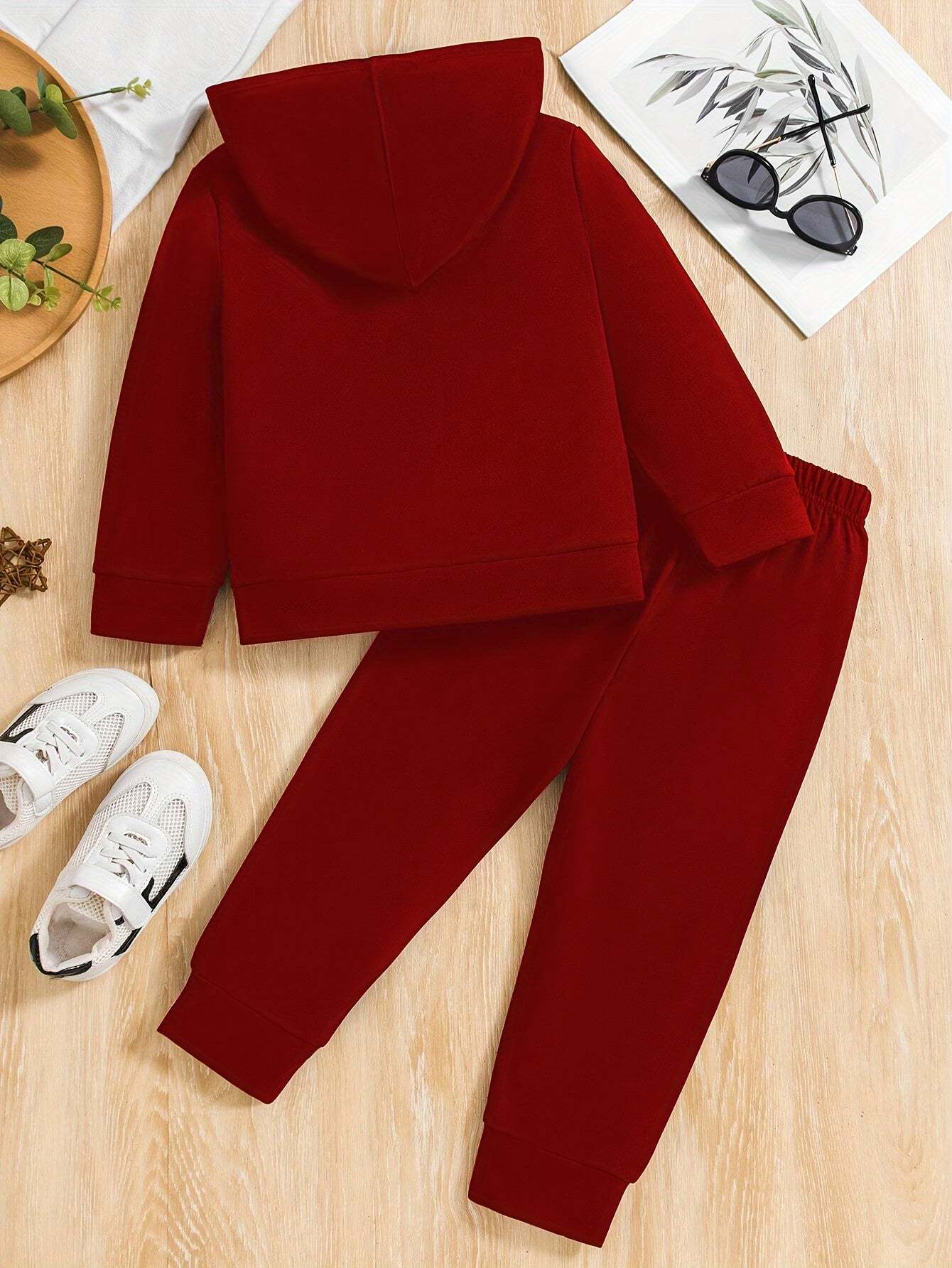 Trendy boys' California print outfit set in red with hooded sweatshirt and pants on a wooden surface.
