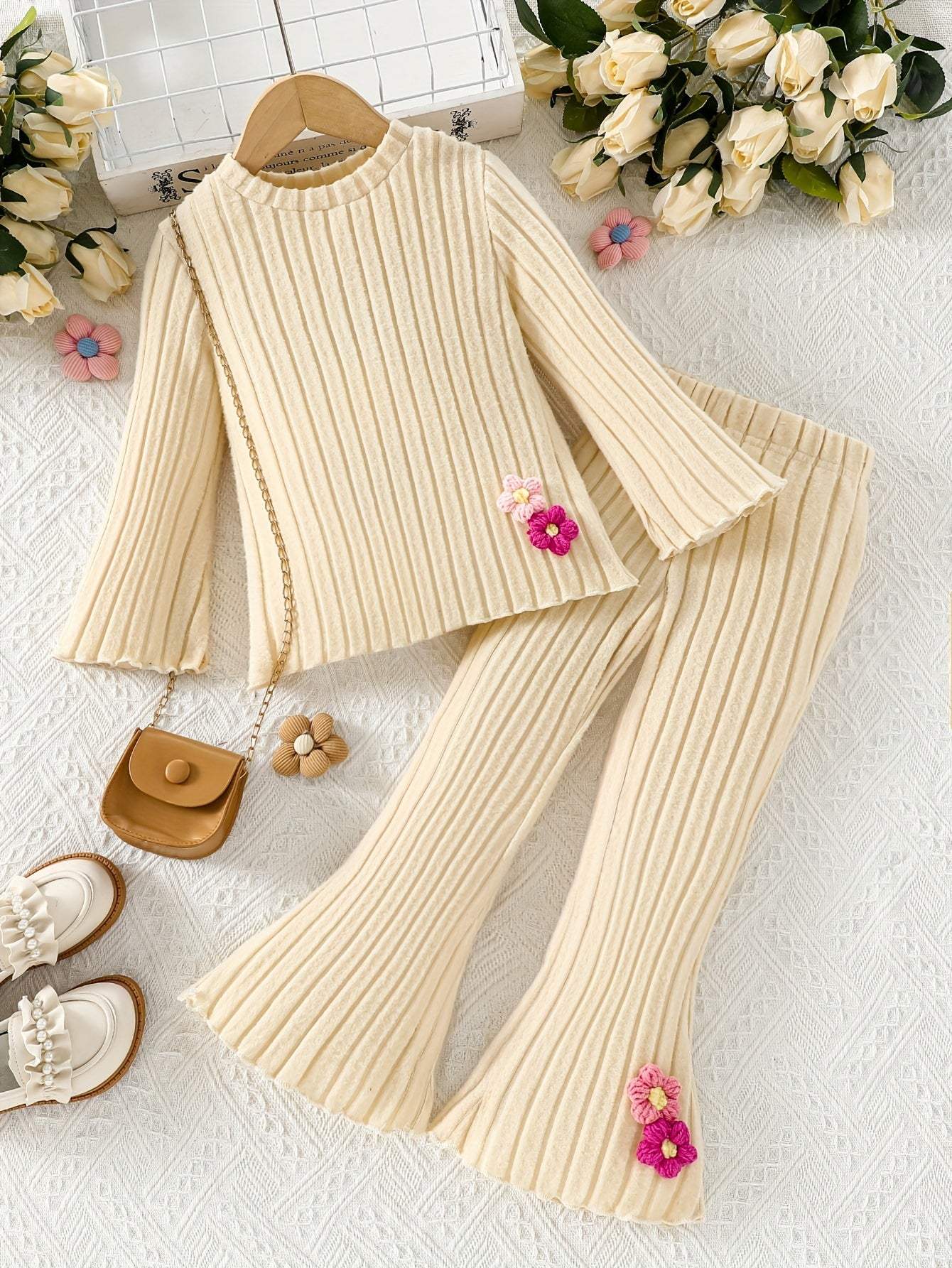 Stylish girls' outfit set in cream, featuring ribbed knit top and pants with floral accents.