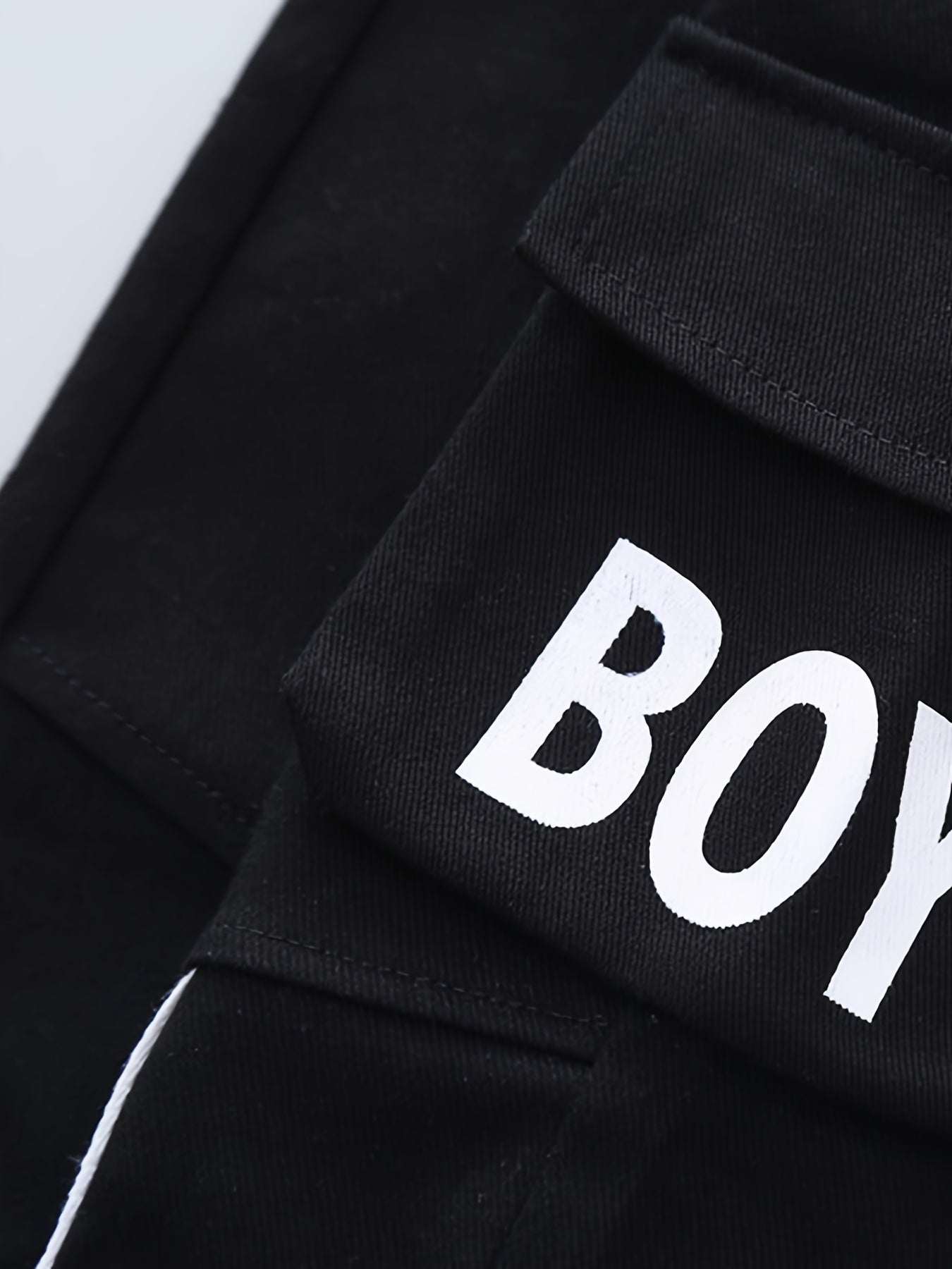 Close-up of trendy boys' three-piece set with bold "Boy" design in high-quality cotton fabric.