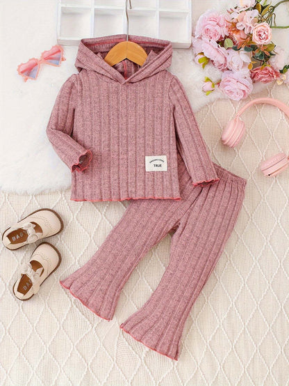 Pretty in pink 2-piece shirt and pants set for kids, ribbed texture, with flowers and headphones in background.