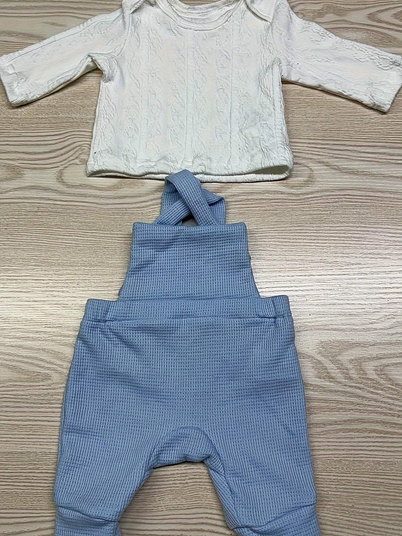 Classic 2-piece kids overall and shirt set with button accents on a wooden surface.