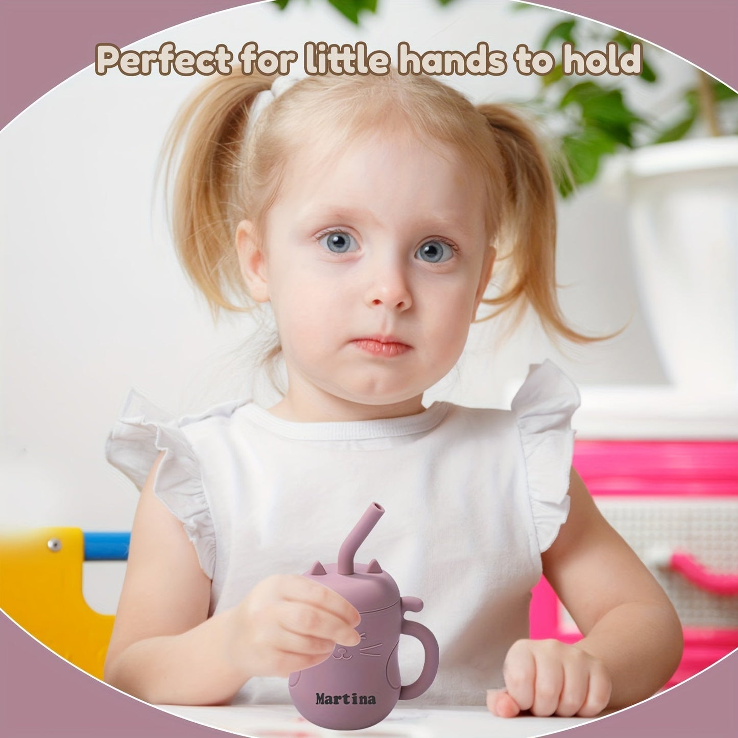 Baby holding a pink kawaii cat learning cup with straw, designed for easy grip.