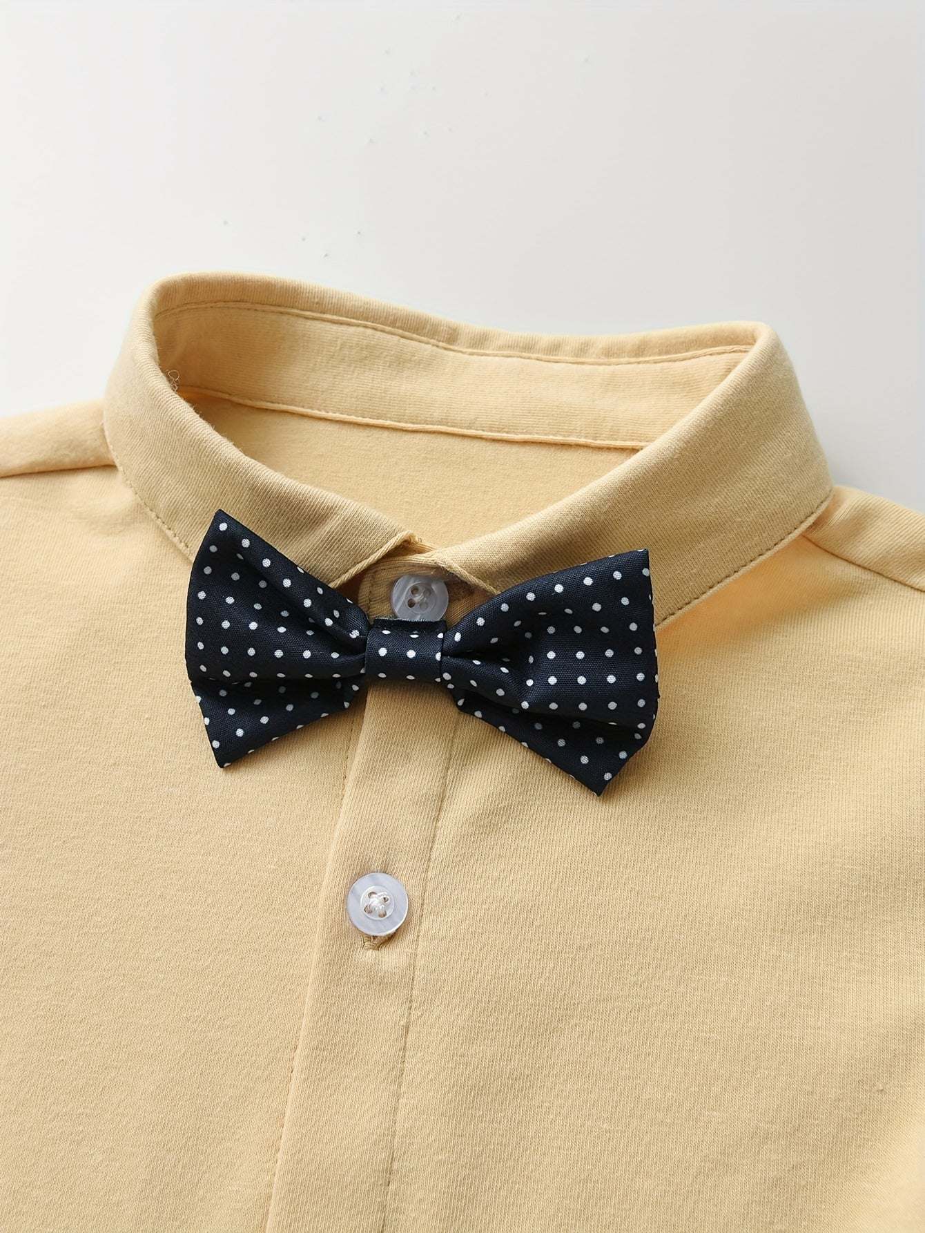 Dapper gentleman boys' suit with polka dot bow tie and collared shirt.