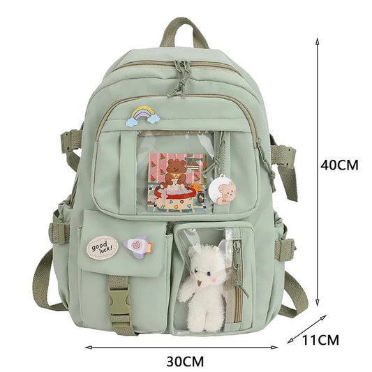 Children's schoolbag with green fabric, multiple compartments, and decorative badges for style and functionality.