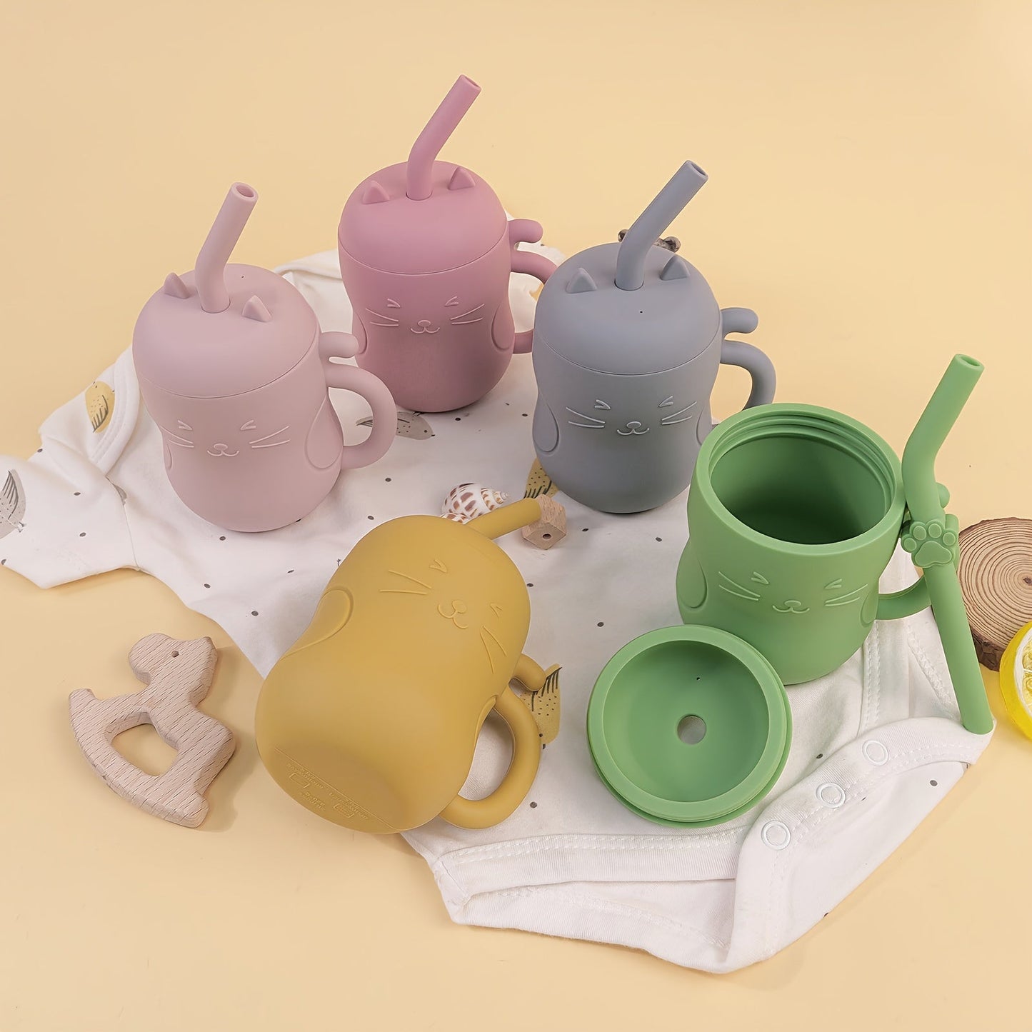 Kawaii leak-proof learning cup for babies with cat design and straw in various colors.